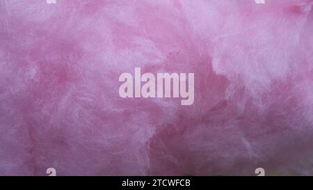 sfondo rosa di materiale soffice e leggero primo piano, morbida trama di vellutata vista macro in caramelle di cotone lilla, delicate fibre di tessuto shaggy come trama Foto Stock