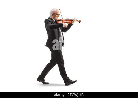 Foto a profilo completo di un uomo con un vestito nero che cammina e suona un violino isolato su sfondo bianco Foto Stock