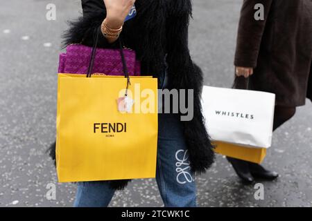 Acquirenti che trasportano borse di abbigliamento firmate FENDI e whistles nel West End di Londra, Inghilterra, Regno Unito Foto Stock