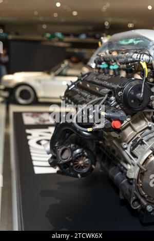 Parte del motore dell'auto. Motore nuovo auto nuova. Motore di un'auto sullo sfondo di un'auto Porsche. Foto Stock
