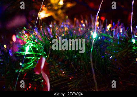 Una serie di luci natalizie, ornamenti e tinsel su un albero. Tutte le immagini scelte sono state modificate con Lightroom Classic. Foto Stock