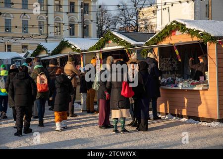 Persone e chalet di mercato al Tuomaan Markkinat o al mercato di Natale di Helsinki in Piazza del Senato a Helsinki, Finlandia Foto Stock