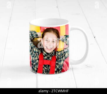 Grande tazza colorata sulla superficie in legno con un bambino stampato su di essa Foto Stock