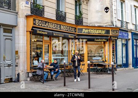 Persone sedute fuori Boulangerie moderne, un panificio artigianale usato nella serie TV Emily a Parigi nel V arrondissement di Parigi, Francia Foto Stock