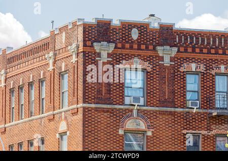 Mattoni policromi e pietre fuse animano Avalon Court, un edificio di appartamenti a quattro piani a Jackson Heights. Foto Stock