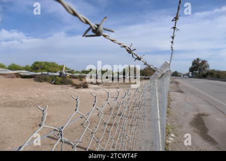 Recinzione in filo spinato sulla strada. Il concetto di limitazione del movimento. Foto Stock