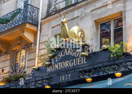 Una grande lumaca dorata sopra l'entrata dell'Escargot Montorgueil , classico ed elegante ristorante francese in Rue Montorgueil a Parigi , Francia Foto Stock