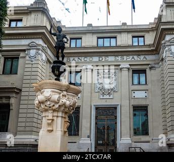 Architettura storica del Banco de Españain Siviglia, Spagna, con sculture ornamentali e bandiere. Foto Stock