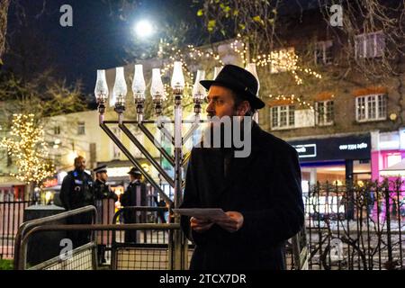 Londra, Regno Unito. 14 dicembre 2023. Un evento di solidarietà a cui hanno partecipato parlamentari, leader della comunità e membri del pubblico si è tenuto oggi dopo che la menorah è stata vandalizzata su Islington Green. Rabbi Mendy Korer guidò il procedimento, alleggerendo le candele - e l'ottava e ultima per il festival Hanukkah. La polizia metropolitana sta indagando, e crede che la menorah sia stata intenzionalmente danneggiata, mentre gli incidenti antisemiti aumentano dopo gli attacchi di Hamas in Israele. Credito: Fotografia dell'undicesima ora/Alamy Live News Foto Stock