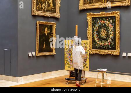 Un'artista donna che copia un dipinto in una galleria all'interno del Museo del Louvre a Parigi, in Francia Foto Stock