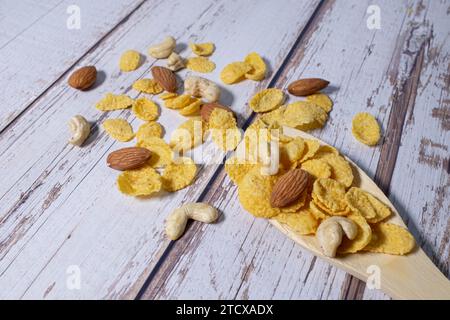 Colazione con cereali in cucchiaio di legno. Muesli sani con fiocchi di avena, noci e uvetta isolati su sfondo bianco. Foto Stock