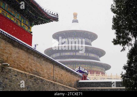 Pechino, Pechino, Cina. 14 dicembre 2023. Il 13 dicembre 2023 nevicò pesantemente a Pechino, e la sala di preghiera, il tumulo circolare e la cupola imperiale nel Parco del Tempio del Paradiso erano pittoreschi nella neve. L'entusiasmo dei turisti per le visite non è diminuito. Gli esperti meteorologici ricordano che ci saranno nevicate e ondate di freddo dal 13 al 16, e sono stati emessi avvisi di bufera arancione, ondata di freddo blu e ghiaccio giallo. Nevicerà per i prossimi due giorni, con basse temperature, scarsa visibilità e strade sdrucciolevoli. Prestare attenzione a mantenere il calore Foto Stock