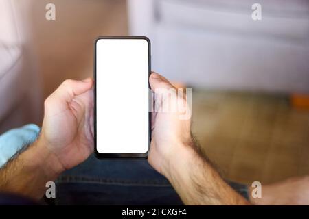 Le mani maschili trattengono un elegante telefono cellulare con schermo vuoto, offrendo un modello versatile per design personalizzati in annunci pubblicitari e campagne. Copia S Foto Stock