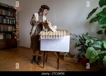 Ragazza che vive uno stile di vita ecologico che raccoglie oggetti da riciclare messi in scatola di cartone. Foto Stock