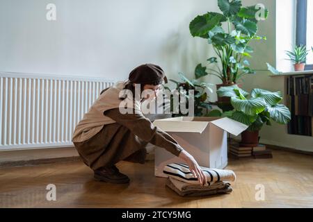 Attivista, volontaria, altruista che raccoglie oggetti da riciclare messi in scatola di cartone. Foto Stock