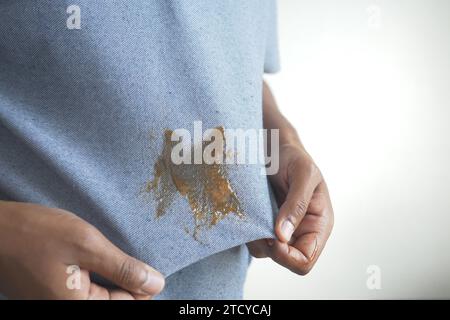Salsa di pomodoro versata su una camicia di colore grigio. Macchie di cibo sulla camicia Foto Stock