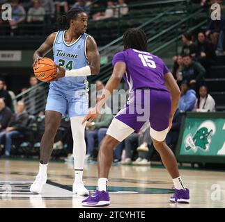 New Orleans, USA. 14 dicembre 2023. L'attaccante di Tulane Green Wave Kevin Cross (24) cerca un compagno di squadra aperto mentre è sorvegliato dall'attaccante dei Furman Paladins Tyrese Hughey (15) durante una partita di basket maschile alla Fogleman Arena di New Orleans, Louisiana, giovedì 14 dicembre 2023. (Foto di Peter G. Forest/Sipa USA) credito: SIPA USA/Alamy Live News Foto Stock