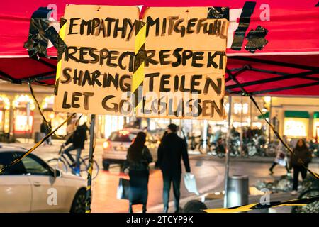 Schild Mitgefühl, Respekt, Teilen, Loslassen abends am Max-Joseph-Platz, Aktion gegen Verschärfung des Asylrechts, München, Dezember 2023 Deutschland, München, Dezember 2023, Schild Mitgefühl, Respekt, Teilen, Loslassen abends am Max-Joseph-Platz, Aktion der Refugees4Refugees gegen die Verschärfung des Asylrechts, im Hintergrund Menschen bei Weihnachtseinkäufen, Bayern, bayerisch, bayerische, Außenaufnahme, inverno, *** segno compassione, rispetto, condivisione, lasciare andare la sera a Max Joseph Platz, azione contro l'inasprimento della legge in materia di asilo, Monaco di Baviera, dicembre 2023 Germania, Monaco di Baviera, 20 dicembre Foto Stock