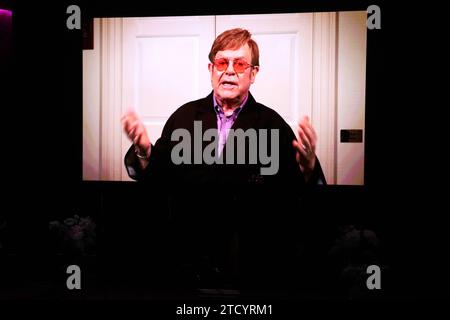 Un video tributo dall'intrattenitore britannico Elton John è mostrato su uno schermo durante lo State Memorial Service per il comico e attore australiano Barry Humphries alla Sydney Opera House di Sydney, venerdì 15 dicembre 2023. Un servizio commemorativo statale per Barry Humphries riconoscerà il contributo degli intrattenitori tardivi alle arti e all'intrattenimento australiani. AAP Image/Pool, David Gray NO ARCHIVING SYDNEY NSW AUSTRALIA *** Un video tributo dall'intrattenitore britannico Elton John è mostrato su uno schermo durante lo State Memorial Service per il comico e attore australiano Barry Humphries alla Sydney Opera House di S. Foto Stock