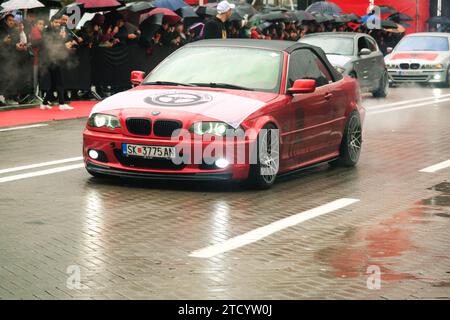 Tirana, Albania - 28 novembre 2023: Sulla Avenue of Martyrs of the Nation, i cittadini guardano una parata di auto modificate in un giorno dell'indipendenza piovoso, con un Foto Stock