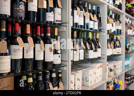 Scaffali con bottiglie di vino e gin di alta qualità in vendita in un negozio di gastronomia locale. Foto Stock