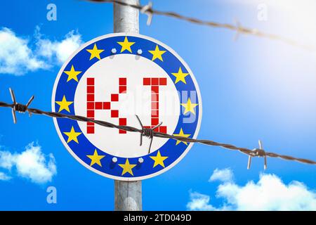 15 dicembre 2023: Firma con bandiera UE dietro una recinzione di filo spinato con l'iscrizione ai Artificial Intelligence PHOTOMONTAGE *** Schild mit EU-Flagge hinter einem Stacheldrahtzahn mit der Aufschrift KI Künstliche Intelligenz FOTOMONTAGE Foto Stock