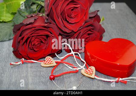 Tè ibrido (Rosa odorata hybrida), rose di baccarat con una scatola di gioielli a forma di cuore e decorazione a cuore Foto Stock