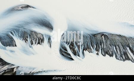 Questa immagine aerea cattura gli intricati schemi di un bacino fluviale ghiacciato in Islanda, mostrando l'arte della natura Foto Stock