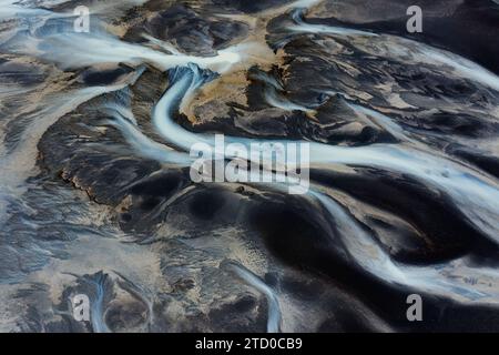 Questa immagine cattura i modelli tortuosi dei bacini fluviali dell'Islanda, mostrando un affascinante arazzo naturale da una prospettiva aerea Foto Stock