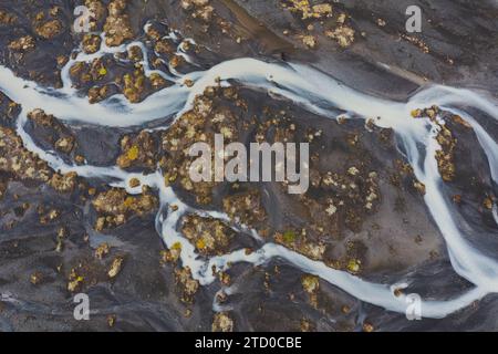 Una ripresa aerea che cattura gli intricati schemi di un bacino fluviale nel paesaggio vulcanico dell'Islanda Foto Stock