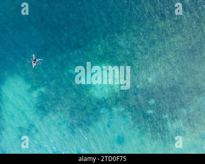 Un colpo aereo cattura una sola persona che galleggia pacificamente nelle acque azzurre e trasparenti del Mar Mediterraneo lungo la Côte costa azzurra vicino a Nizza, Foto Stock