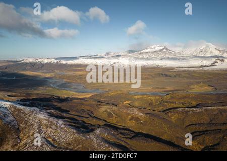 Una vista aerea del contrastante paesaggio islandese caratterizzato da montagne innevate e modelli di colori autunnali. Foto Stock