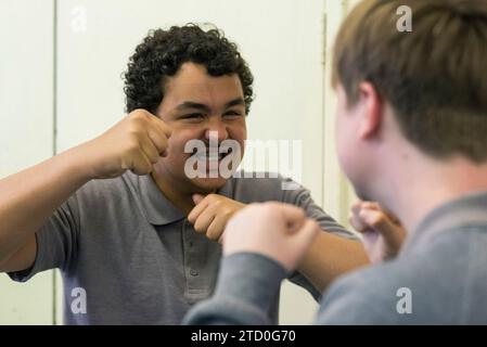 Gli studenti della sala di teatro stanno provando una performance per uno spettacolo per GCSE Drama Foto Stock