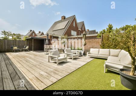 Mobili da salotto all'aperto nello splendido patio sul retro di una casa contemporanea contro il cielo nelle giornate di sole Foto Stock