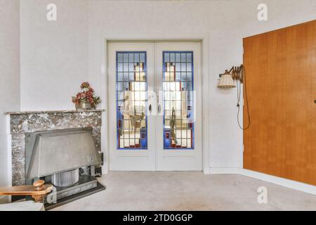 Caminetto a porte chiuse nel moderno soggiorno della casa contemporanea con pavimento e parete bianchi Foto Stock