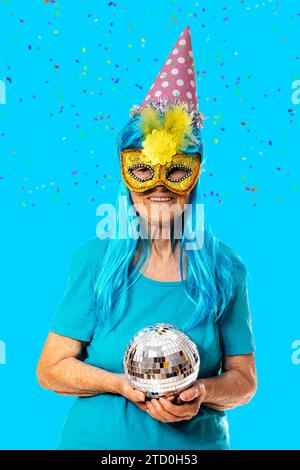 Divertente donna anziana con una maschera di carnevale e un bicchiere di  spumante pronto a divertirsi a casa, in attesa di visitatori Foto stock -  Alamy