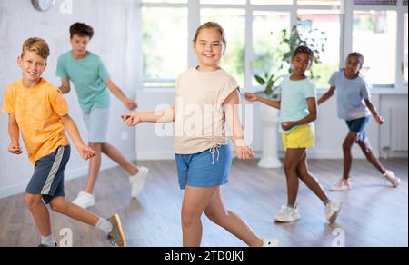 Sorridente tra una ragazza che impara danze dinamiche moderne in una lezione di coreografia Foto Stock
