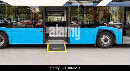 Fermata dell'autobus. Rampa autobus piano basso. Mezzi pubblici accessibili con sedia a rotelle. Rampa autobus piano basso. Foto Stock