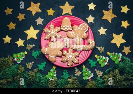 Biscotti di pan di zenzero natalizio di un uomo, fiocchi di neve, campana, stella, albero concetto di una vigilia di Natale con luna piena in una foresta, buon Natale e felice Foto Stock