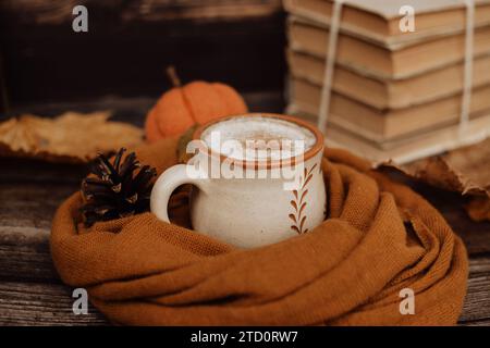 Caffè piccante e piccante e un mucchio di vecchi libri su sfondo in legno Foto Stock