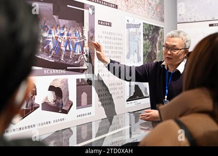 (231215) -- TIANJIN, 15 dicembre 2023 (Xinhua) -- li Zhe (2nd R) elabora una struttura della grande Muraglia mentre i visitatori ascoltano durante una mostra sulla realizzazione delle loro ricerche al Museo Tianjin di Tianjin, nella Cina settentrionale, 12 febbraio 2023. Li Zhe, 45 anni, ricercatore ospite presso la Scuola di architettura dell'Università di Tianjin, dedica il suo tempo alla conservazione delle immagini della grande Muraglia, una reliquia culturale. Nel tentativo di preservare le immagini della grande Muraglia e garantire l'uso sostenibile dei dati, un team di ricerca con la Scuola di architettura dell'Università di Tianjin ha avviato un progetto alla fine del 2018 Foto Stock