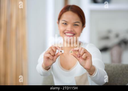 donna sorridente che mostra schede sim Foto Stock