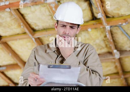 costruttore pensivo in piedi con appunti Foto Stock