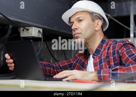 supporto tecnico su scala per collegare i cavi in fibra ottica Foto Stock