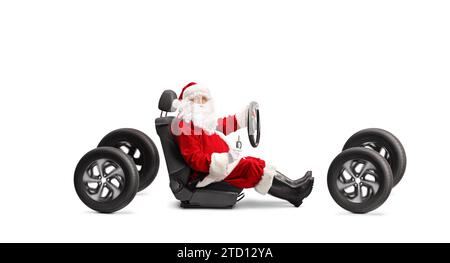 Babbo Natale su un seggiolino per auto su quattro ruote che reggono un volante e tasti isolati su sfondo bianco Foto Stock