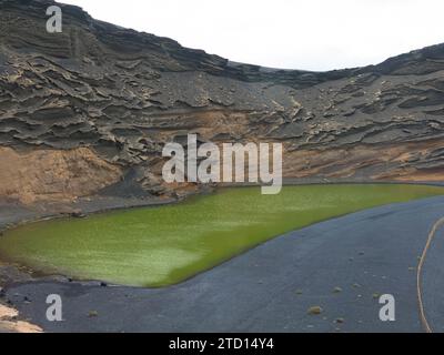 Splendida vista di El Lago Verde. Laguna verde con oceano Atlantico e spiaggia di sabbia nera. Famoso punto panoramico. Lanzarote, Isole Canarie, Spagna, Europa Foto Stock