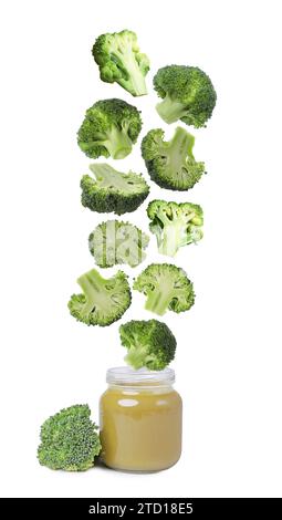 Cibo per bambini. Broccoli freschi che cadono in vasetto di purea su sfondo bianco Foto Stock