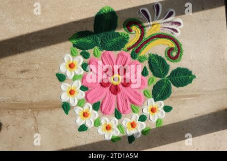 Splendidi disegni Rangoli realizzati per il festival indiano. motivi di rangoli con fiori rosa Foto Stock