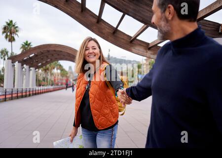 Felice e sorridente coppia caucasica di mezza età innamorata che si tiene per mano guardarsi l'un l'altro. Foto Stock