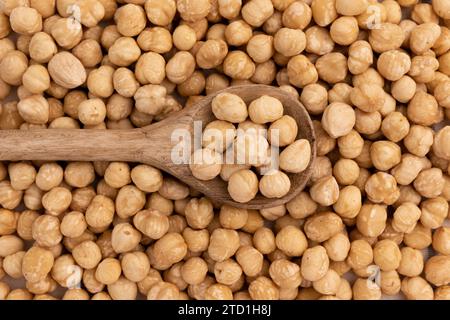 mucchio di nocciole in cucchiaio su fondo di noci primo piano, vista dall'alto, concetto di cibo sano Foto Stock